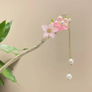 Detail einer Vintage-Haarnadel mit rosa Blumen und goldenen Quasten mit weißen Perlen