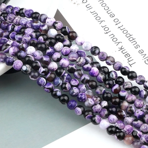 Detailed view of purple and black agate beads with natural patterns for DIY jewelry making
