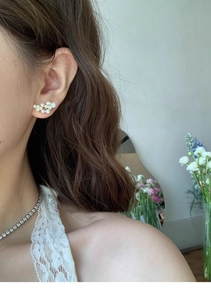 Elegant floral pearl earring with gold plating shown on model in a soft floral setting