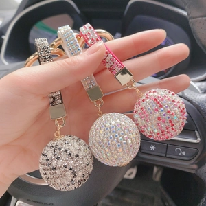 Close-up of sparkling rhinestone crystal ball keychains in black, white, and pink
