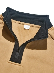 Détail d'un sweat kaki à demi-zip avec col montant contrasté noir et étiquette de taille L