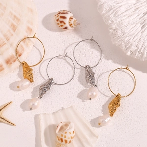 Detail of seashell charm and freshwater pearl on 18K gold and silver plated hoop earrings