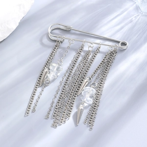 Close-up of silver-tone tassel safety pin brooch with metallic chains and crystal beads
