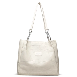 White geometric patchwork tote bag with silver chain straps shown on a white background