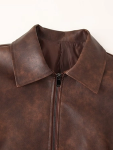 Détail d'une veste en similicuir marron vintage avec revers classique et fermeture éclair