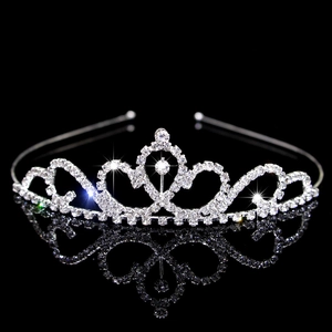 Elegant silver tiara with sparkling crystal rhinestones on a reflective black surface