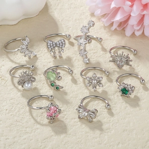 Flat lay of a 10-piece silver ear cuff set with pearls, zircons, and floral motifs