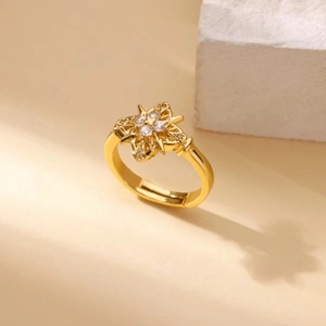 Detail of adjustable gold ring featuring a star cross pattern and clear zircon stones