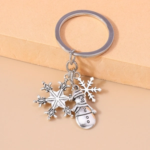Detail of silver alloy Christmas keychain with snowflake and snowman charms in retro style