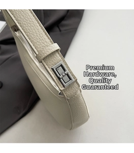 Details von hochwertigem Leder mit Lychee-Muster und Silberschnalle an cremefarbener Tasche