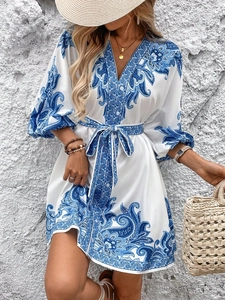 Close-up of V-neckline and bohemian paisley print on a blue and white summer dress
