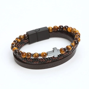 Detail of tiger eye beads, braided brown leather, and silver metal cross charm with magnetic clasp