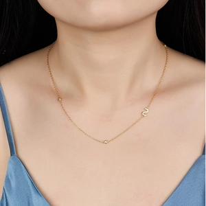 Close-up of a gold S925 silver necklace with an S letter pendant on a female model