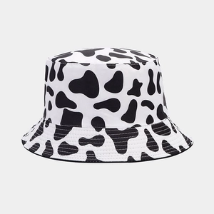 Close-up of reversible bucket hat with cow print pattern and reinforced stitching details