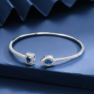 Luxury adjustable open bangle with pear and square blue gemstones in silver setting