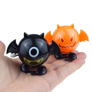 Close-up of wind-up walking orange pumpkin and black bat toys for Halloween
