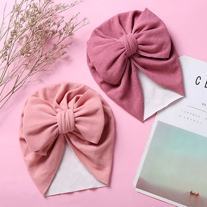 Detail of infant turban hats with double bows in soft pink and dark pink knit fabric