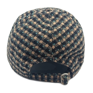 Detail view of houndstooth wool baseball cap showing adjustable strap and metal buckle