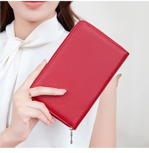 Close-up of red pebbled leather long wallet with metal zipper held by a model