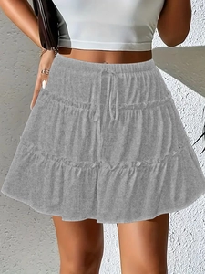 Detailed view of grey tiered mini skirt featuring adjustable drawstring waist and layered ruffle