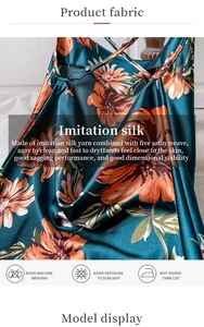Detail of silk-like dark green floral slip dress showing satin texture and draping