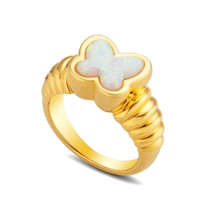 Close-up of golden butterfly opal ring with textured band on a clean white background