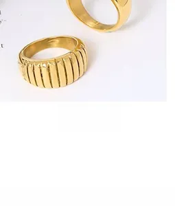 Nahaufnahme goldener Croissant-Ringe im Vintage-Stil mit Plissee-Textur auf Magazin