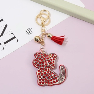 Detail of red and silver rhinestone cat keychain with golden hardware and red tassel