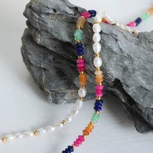 Vintage baroque freshwater pearl and colorful natural stone beaded necklace on grey rock