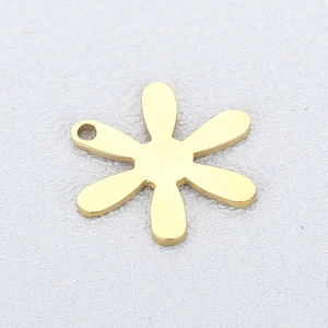 Nahaufnahme eines goldenen sechsblättrigen Blumenanhängers mit glatter Metalloberfläche