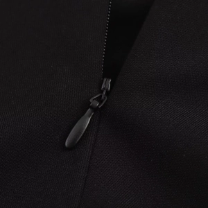 Close-up of a concealed invisible zipper with teardrop pull on black knit fabric