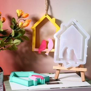 Detail of bird house silicone mold for resin casting with colorful bird pendant samples