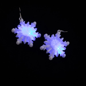 Close-up of snowflake LED earrings with blue glowing light effect on dark background