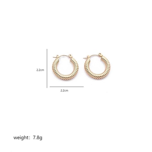 Close-up of golden twist hoop earrings with detailed spiral texture and 2.2cm diameter