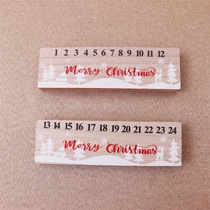 Detail of wooden advent calendar featuring white reindeer and pine tree desktop decor