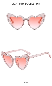 Close-up of pink heart-shaped sunglasses with shimmering rhinestones and glitter temples