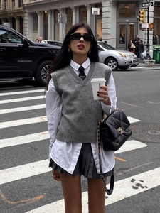 Women's V-neck knitted vest paired with white shirt and grey pleated skirt streetwear