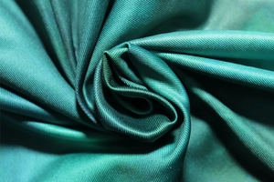 Detailed close-up showing the dark green twill fabric texture and silky matte finish