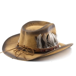 Detail of vintage straw cowboy hat featuring woven texture, rustic feathers, and leather cord