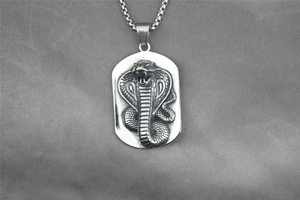 Detailed relief of an embossed cobra on a rectangular silver pendant with a metal chain