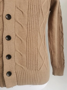 Details des kamelfarbenen Strickcardigans mit grober Struktur und schwarzen Knöpfen