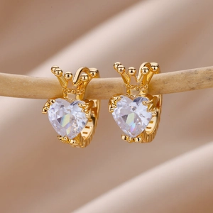 Macro shot of 18K gold plated heart zircon earrings with crown design on wood