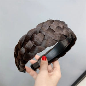 Close-up of a wide braided fishbone hairband in deep brown with realistic hair texture