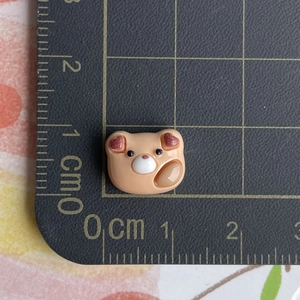 Detailed scale view of a miniature brown resin teddy bear charm for DIY crafts and jewelry