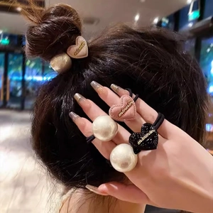 Élastique à cheveux élégant avec perle et pendentif cœur rose sur une coiffure en chignon