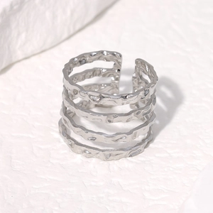 Macro detail of silver stainless steel ring with minimalist irregular wavy hammer texture