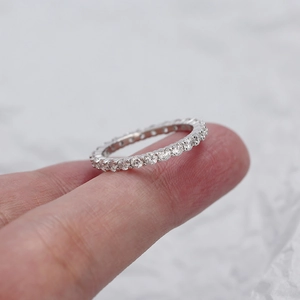Close-up of a 925 sterling silver eternity ring with sparkling cubic zirconia on a finger