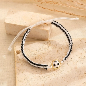 Detail van een handgeweven zwart-witte voetbalarmband op een getextureerde stenen display