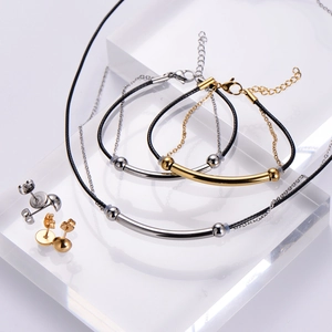 Minimalist two-tone gold and silver jewelry set with metal chain and black cord detail