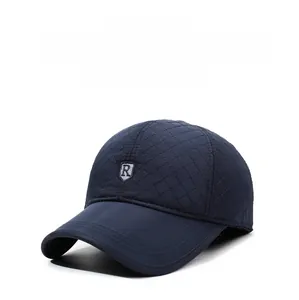 Macro view of navy blue quilted baseball cap with warm lining and metal R logo